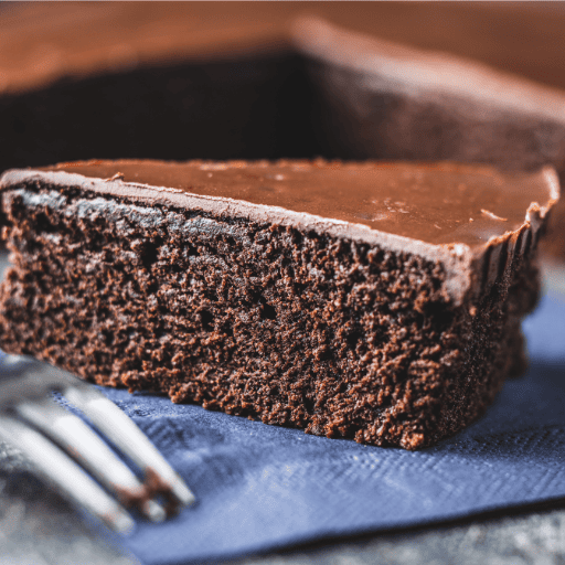 A slice of homemade artisan cake served alongside a coffee at Lavi Café in London.